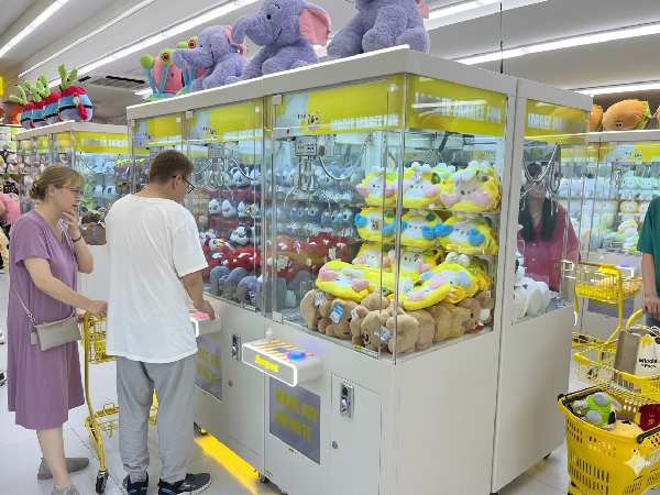 A player carefully choosing a claw machine
